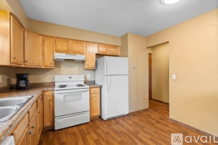 A kitchen with wooden cabinets and a white refrigerator.
