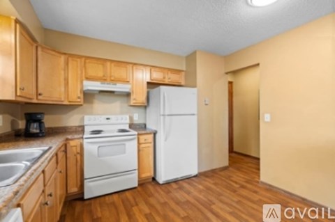 A kitchen with wooden cabinets and a white refrigerator.