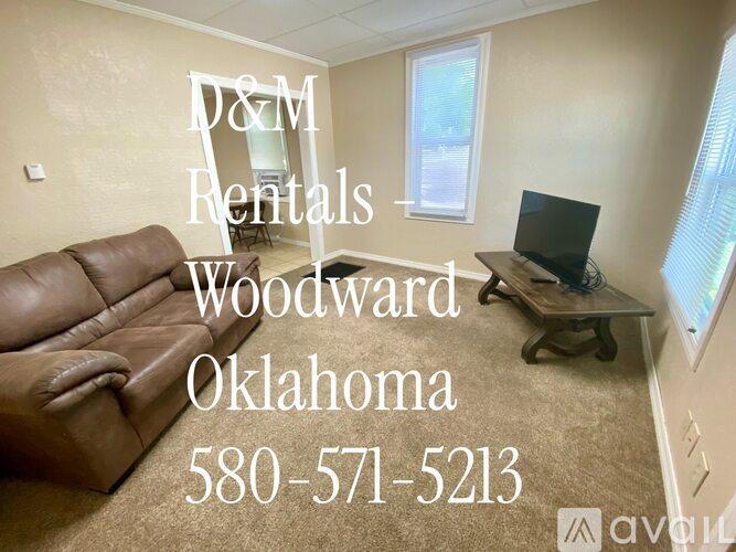 A living room with a couch and a TV, advertising D&M Rentals in Woodward, Oklahoma.