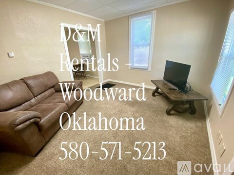 A living room with a couch and a TV, advertising D&M Rentals in Woodward, Oklahoma.