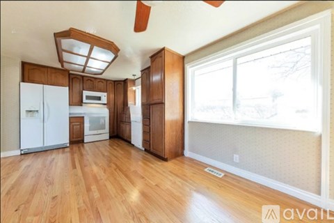 A kitchen with wooden cabinets and a white refrigerator.