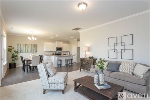 A living room with a grey couch, a coffee table, and a dining table with chairs.