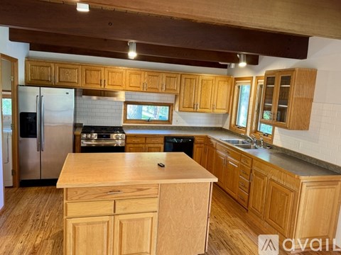 A kitchen with wooden cabinets and a wooden island.