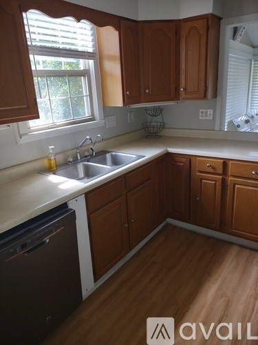 A kitchen with wooden cabinets and a white sink.