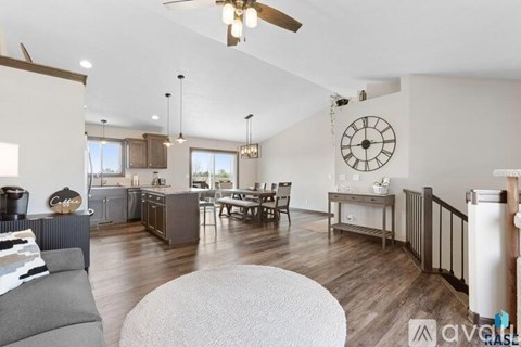 A living room with a grey sofa and a wooden floor.