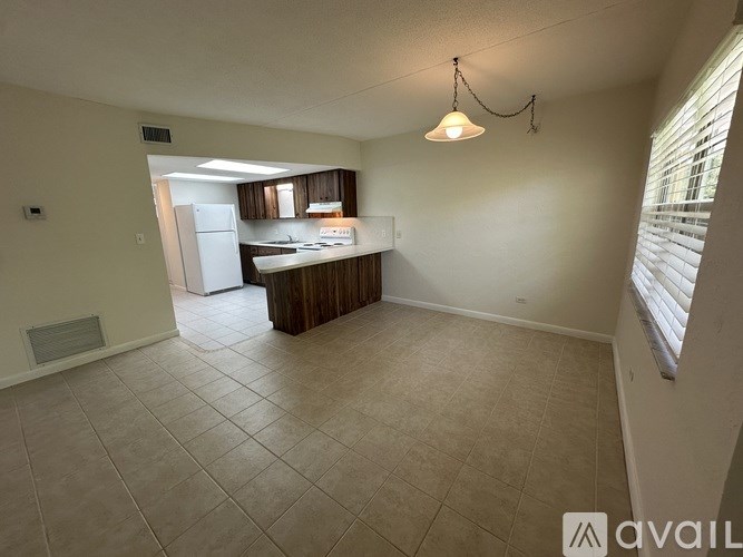 A kitchen area with a refrigerator, sink, and cabinets.