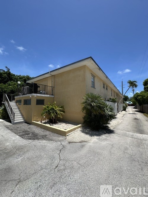 A house with a balcony and a small garden in front.