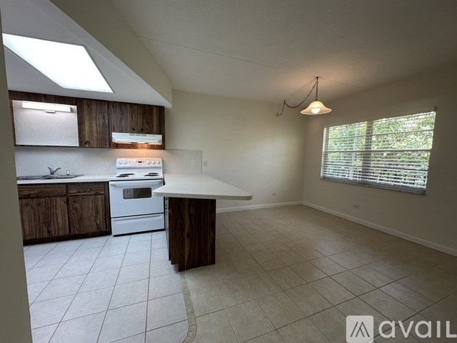 A kitchen with a white countertop and wooden cabinets.