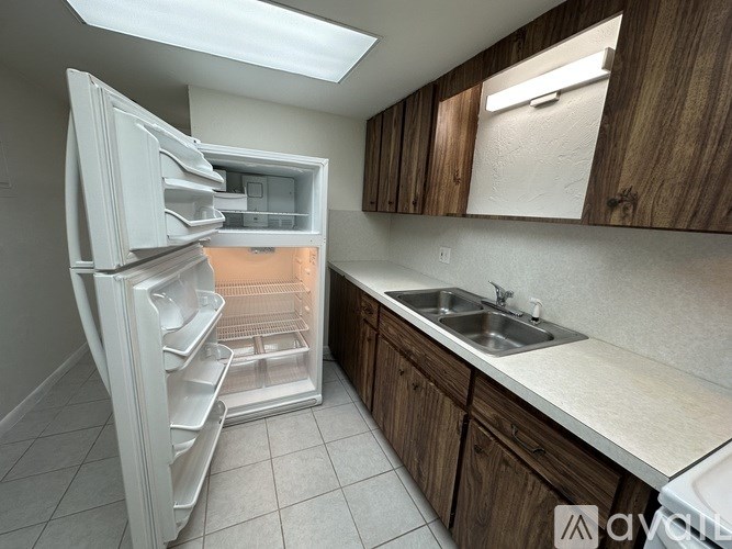 A kitchen with a white refrigerator and wooden cabinets.