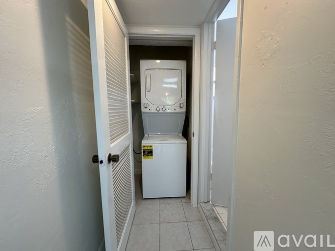 A white tankless water heater in a narrow hallway.