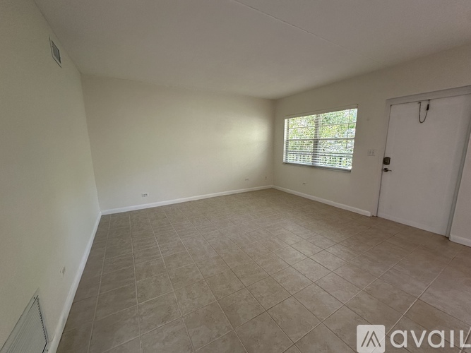 A room with a tiled floor and a window with blinds.