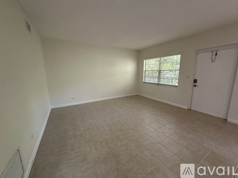 A room with a tiled floor and a window with blinds.