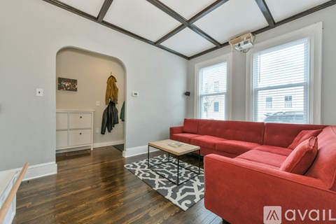 A living room with a red couch and a coffee table.