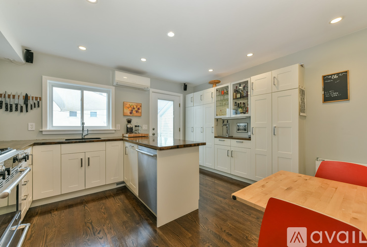 A kitchen with white cabinets and a wooden table.