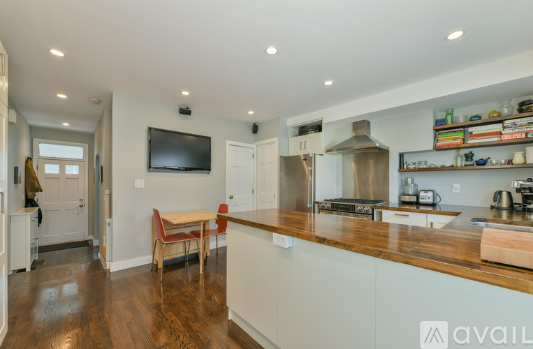 A kitchen with a wooden counter top and white cabinets.