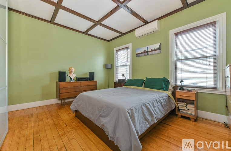 A bedroom with a bed, nightstand, and window.