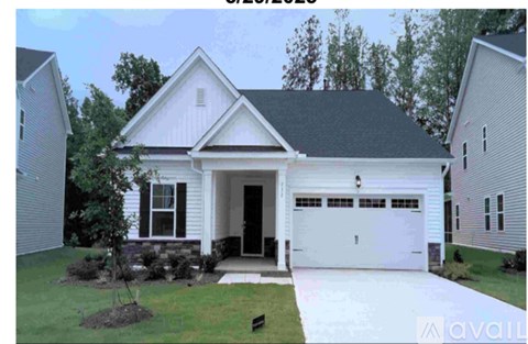 A white house with a black roof and a garage door.