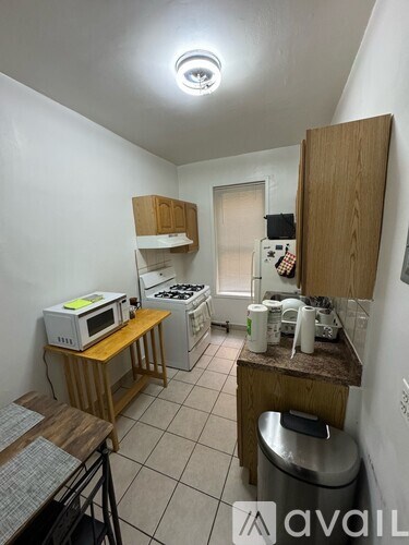 A small kitchen with a microwave, oven, and a sink.