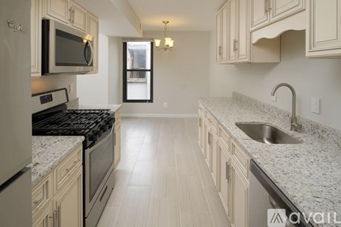 A kitchen with granite countertops and wooden cabinets.