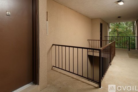 A balcony with a metal railing and a brown door.