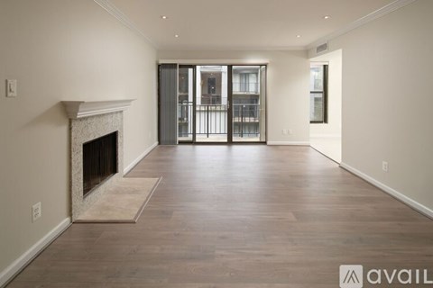 A spacious living room with a fireplace and hardwood floors.