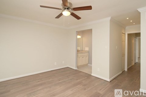 A room with a ceiling fan and wooden flooring.