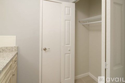 A white closet with a door open and shelves inside.