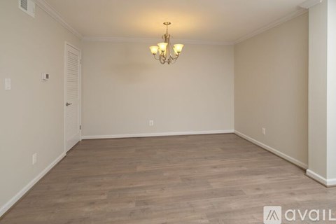 A room with wooden flooring and a chandelier.