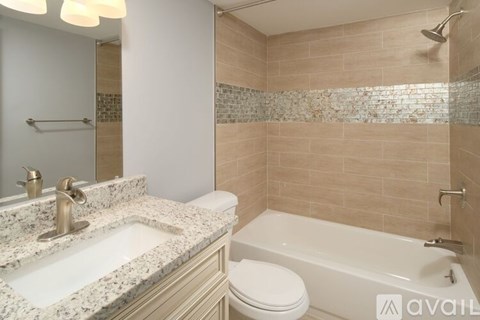 A bathroom with a sink, toilet, and bathtub.