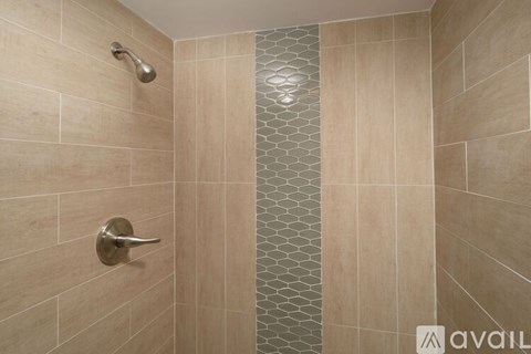 A bathroom with a shower area and a glass door.