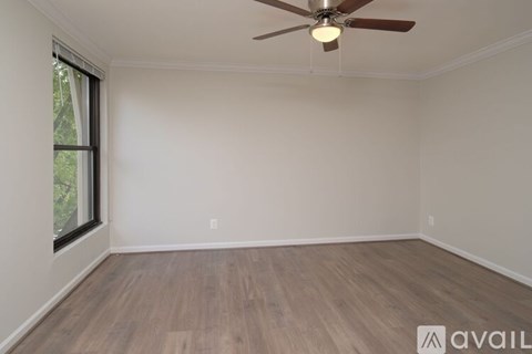 A room with a ceiling fan and wooden flooring.