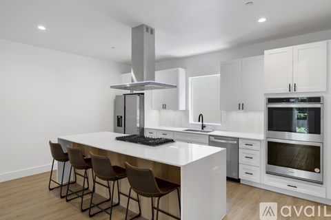 A modern kitchen with white cabinets and a central island.