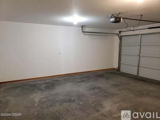 A spacious garage with a concrete floor and a white wall.