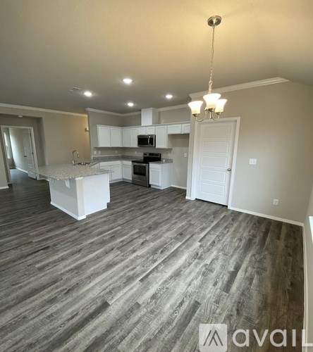 A kitchen with white cabinets and a wooden floor.