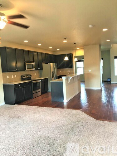 A kitchen with black cabinets and a white island.