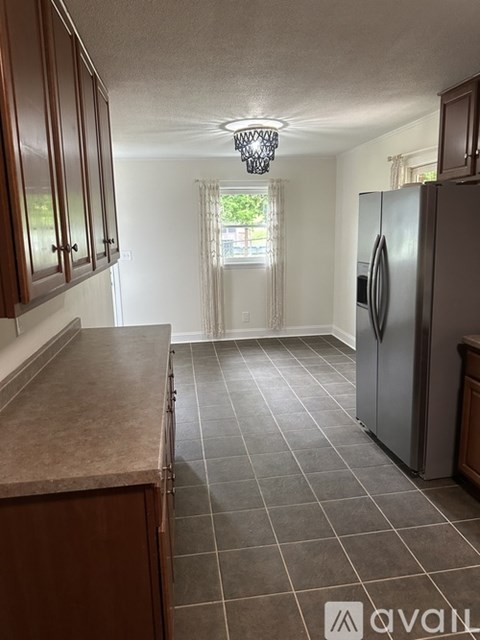 A kitchen with brown cabinets and a silver refrigerator.