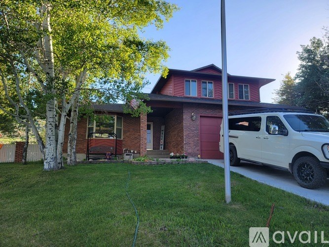 A house with a red door and a white van parked in front.