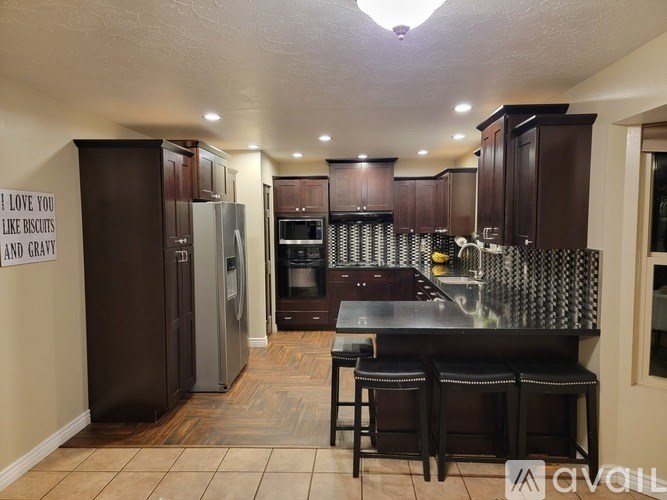 A kitchen with brown cabinets and a black countertop.