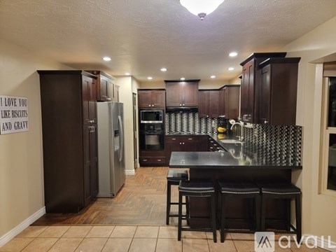 A kitchen with brown cabinets and a black countertop.