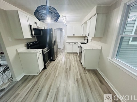 A kitchen with white cabinets and a black stove top oven.