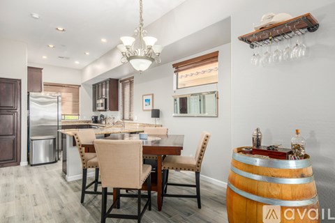 A kitchen with a dining table and chairs.