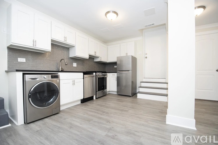 A kitchen with white cabinets and a grey floor.