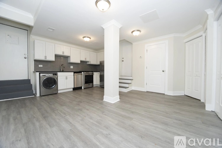 A modern kitchen with a washer and dryer built into the cabinetry.