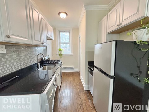 A kitchen with a black stove top oven and white cabinets.