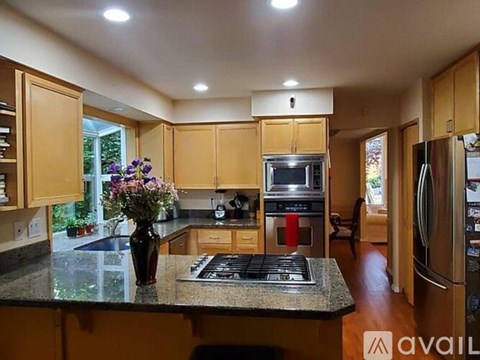 A kitchen with wooden cabinets and a granite countertop.
