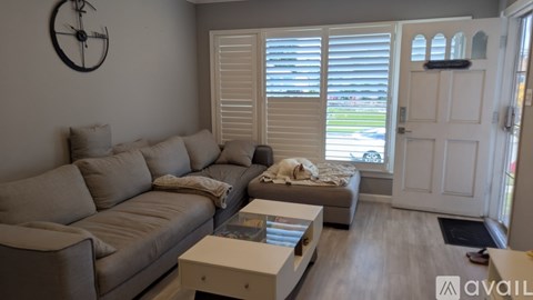 A living room with a grey couch and a white coffee table.