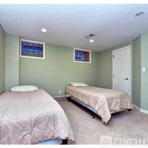 A bedroom with two beds and a window.