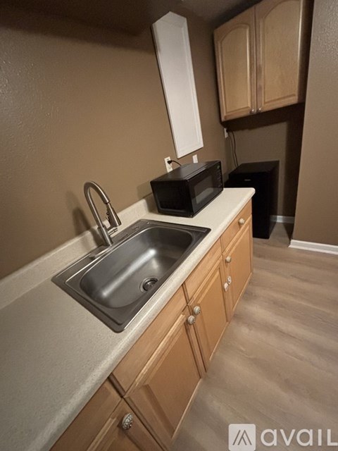 A kitchen with a sink and a microwave on the counter.