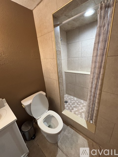 A bathroom with a toilet, sink, and shower area.