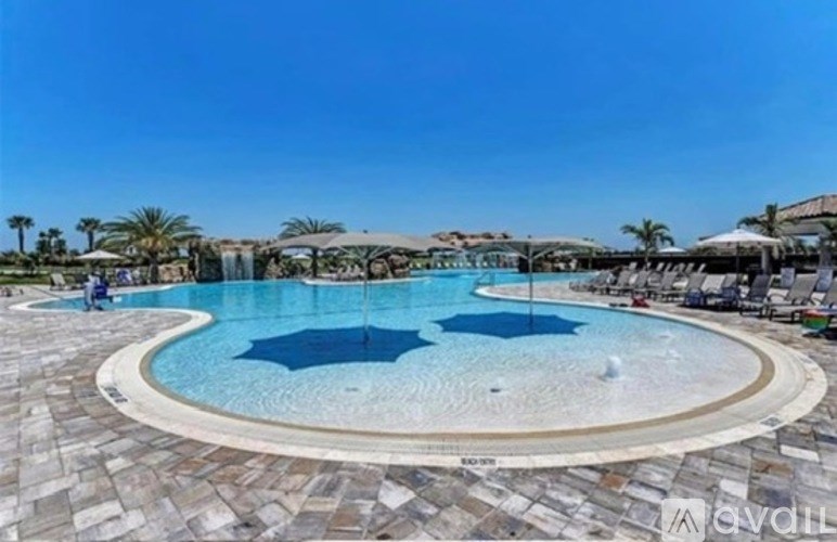 A large outdoor swimming pool surrounded by a stone patio.